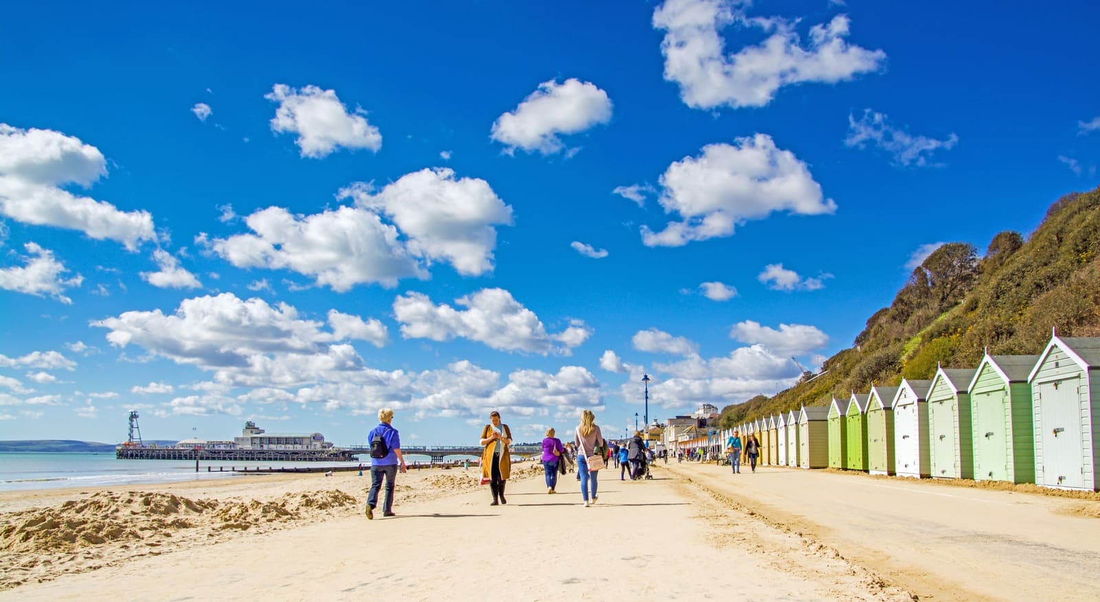 The promenade and beach huts with Bournemouth Pier in the distance